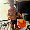 Garrett joined the competition — help win amazing prizes! child, toddler, costume, woody, toy_story, halloween, pumpkin_bucket, cowboy_hat, cowboy_boots, indoor, carpet, door, metal_trash_can, toy, dress_up, cute, person, floor, window, expression