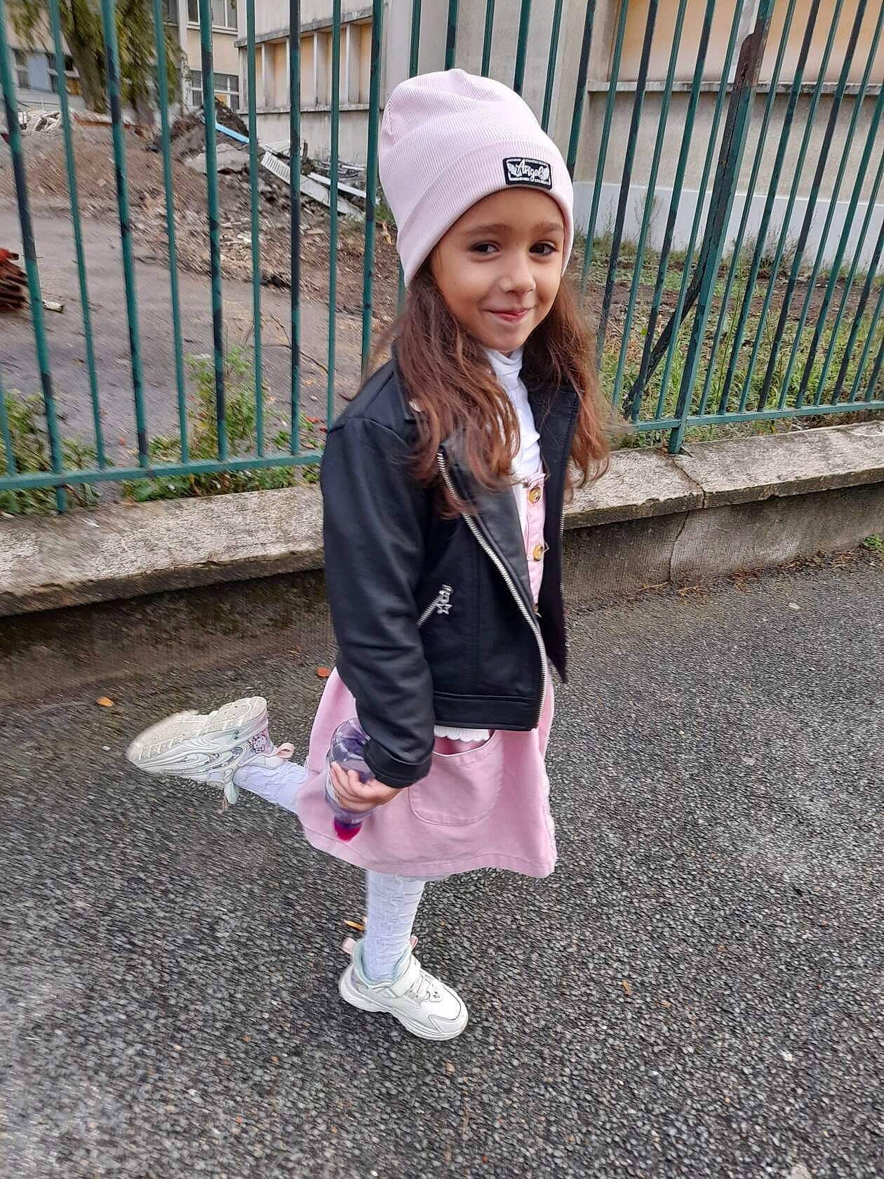 Eva a rejoint le concours — aidez-le/la à gagner de superbes lots ! bangs, cap, child, fashion_accessory, fence, grass, headwear, jacket, joy, leisure, outerwear, pattern, person, pink, plaid, plant, recreation, shoe, sleeve, smile