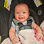 baby, car_seat, smiling, blanket, teething_toy, infant, child, safety_harness, cute, happy, clothing, face, person, indoor, padded, holding, close_up, soft_toy, rosy_cheeks, bright_eyes