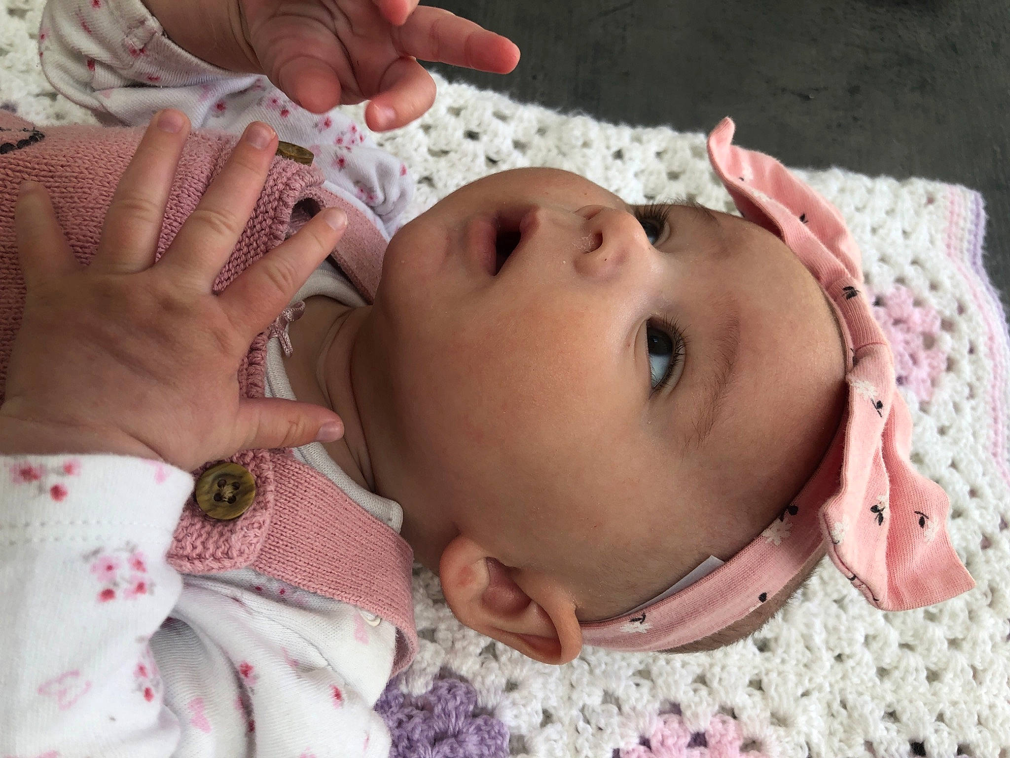 Lydia is registered to the contest to win money with this photo: baby, baby_toddler_clothing, cheek, chin, ear, eye, eyebrow, eyelash, face, facial_expression, finger, gesture, hand, head, headwear, lip, mouth, neck, nose, person