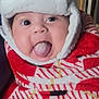 Celeste joined the competition — help win amazing prizes! baby, child, face, tongue, hat, bear_hat, blanket, red_blanket, cozy, indoor, cute, warm_clothing, person, portrait, smiling, headwear, infant, expression, playful, closeup
