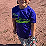 child, baseball, sports, glove, cap, purple_shirt, little_league, outdoor, field, dirt, grass, smiling, standing, young_player, team, spectators, sunlight, casual_shoes, boy, recreation