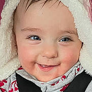 London joined the competition — help win amazing prizes! baby, child, face, smiling, hood, car_seat, seatbelt, clothing, red_pattern, white, cute, portrait, indoor, infant, young_child, happy, skin, eyes, babywear, seat