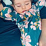 London is registered to the contest to win money with this photo: baby, sleeping, floral_onesie, child, person, adult, hand, cozy, comfort, rest, bed, blanket, closeup, portrait, indoor, cute, peaceful, relaxation, family, toddler