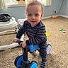 Wyatt is registered to the contest to win money with this photo: baby_walker, carpet, child, cute, daylight, face, floor, furniture, home, indoor, pajamas, person, play, smiling, striped_clothing, toddler, toy, tricycle, window, young_child