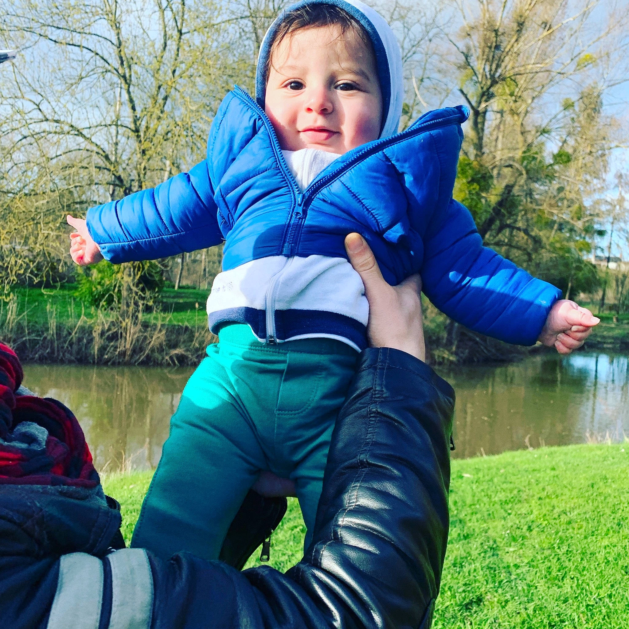 Karim participe au concours pour gagner de l'argent avec cette photo : blue, cheek, child, cool, eye, grass, green, hood, jacket, jeans, joint, leg, male, outerwear, person, personal_protective_equipment, play, sitting, sleeve, toddler