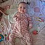 baby, infant, smiling, onesie, play_mat, toy, pacifier, crib, soft_toy, patterned, cute, happy, lying_down, indoors, child, face, hand, foot, colorful, cheeky