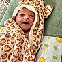 Victoire a rejoint le concours — aidez-le/la à gagner de superbes lots ! baby, infant, towel, heart_pattern, hood, smile, face, wrapped, blanket, green, texture, cute, newborn, lying_down, soft, cozy, child, indoors, happy, person