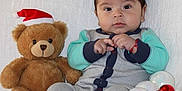 Neithan is registered to the contest to win money with this photo: baby, child, christmas_hat, christmas_ornaments, couch, cozy, curious, cute, festive, holiday, holiday_decor, indoor, infant, plush, portrait, sitting, teddy_bear, toy, warm_clothing, white_blanket