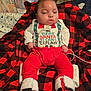 Jeremy is registered to the contest to win money with this photo: baby, blanket, boots, checkered_pattern, child, christmas_clothing, cozy, cute, face, festive, holiday_outfit, indoors, infant, person, red_pants, relaxed, sitting, sleeping, smiling, white_shirt