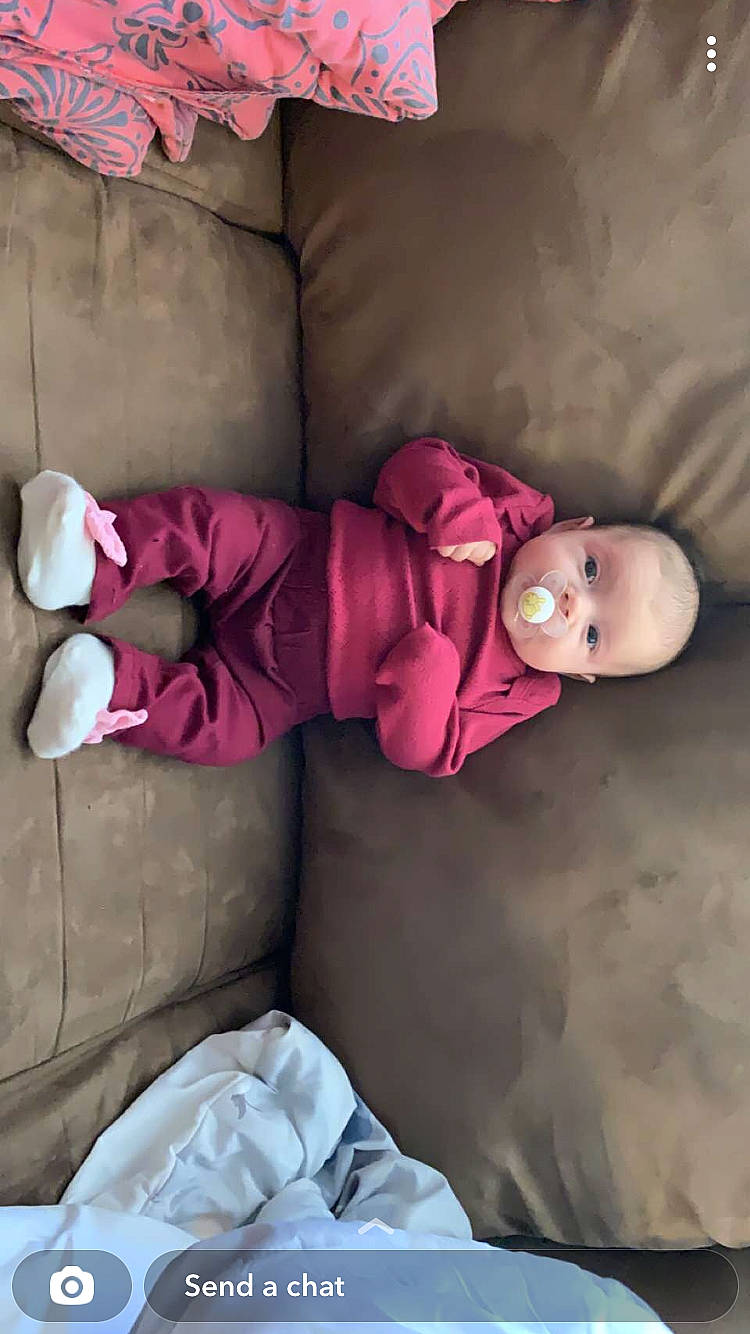 Reilynn is registered to the contest to win money with this photo: baby, baby_toddler_clothing, child, comfort, facial_expression, finger, knee, leg, linens, magenta, mammal, mouth, person, pink, purple, skin, sleeve, sock, textile, thigh