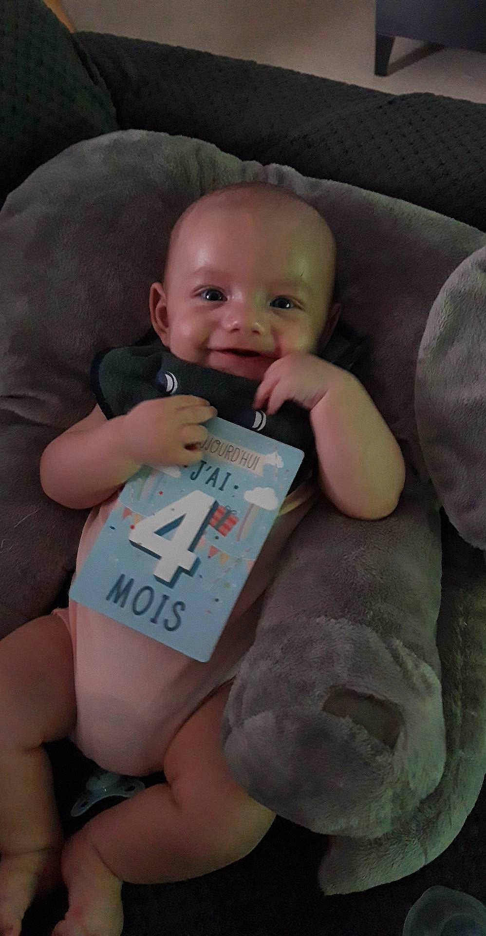 Lény participe au concours pour gagner de l'argent avec cette photo : arm, baby, baby_toddler_clothing, cheek, child, comfort, facial_expression, finger, happy, human, mouth, nail, organ, person, pink, product, skin, smile, textile, thumb