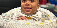 Damon is registered to the contest to win money with this photo: baby, smile, infant, baby_seat, clothing, pattern, happy, child, indoor, person, cute, seated, face, head, eyes, mouth, tongue, skin, cheerful, furniture