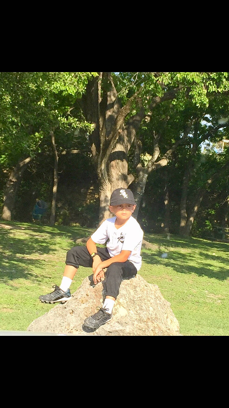 Carlos is registered to the contest to win money with this photo: fun, grass, headwear, lawn, leisure, person, photography, plant, sitting, tree