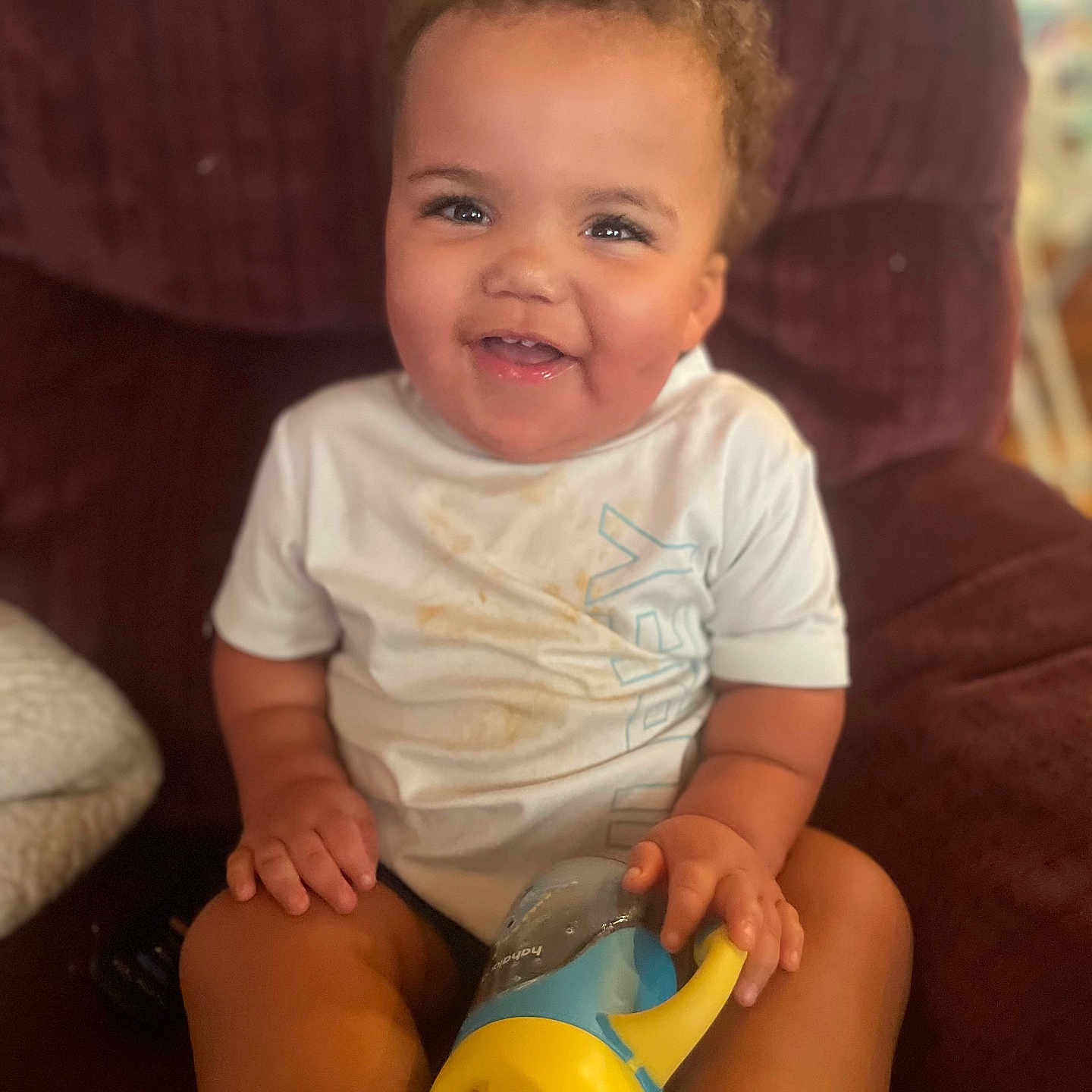 Princtyn joined the competition — help win amazing prizes! casual, chair, child, curly_hair, face, furniture, hand, happy, indoor, legs, messy_shirt, person, plush, relaxed, seated, sippy_cup, skin, smiling, toddler, white_shirt