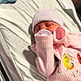 newborn, baby, pacifier, pink_clothing, hat, striped_hat, m_and_ms, onesie, bed, blanket, crib, infant, sleepy, closeup, person, soft_lighting, indoors, cute, baby_toys, sleep