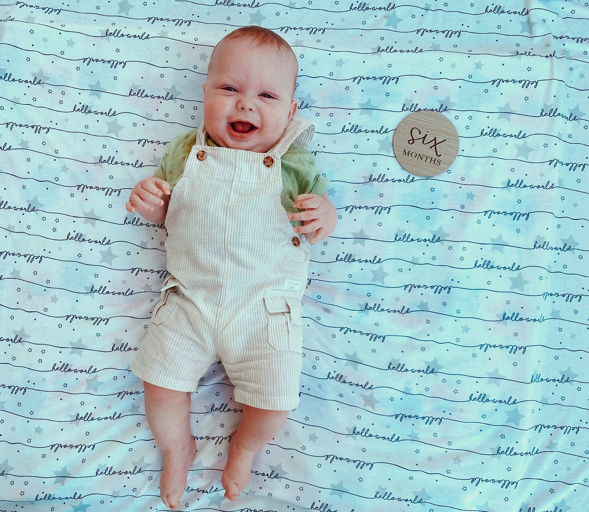 Aziel is registered to the contest to win money with this photo: baby, baby_toddler_clothing, child, flooring, font, gesture, handwriting, happy, human_leg, linens, pattern, people_in_nature, person, sleeve, smile, t_shirt, textile, toddler, waist, writing