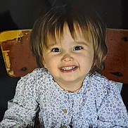 Mélina a rejoint le concours — aidez-le/la à gagner de superbes lots ! toddler, child, smiling, happy, face, portrait, table, wooden_chair, clothing, floral_pattern, long_sleeves, hands, indoor, cute, young_child, person, casual, bright_eyes, baby, seated