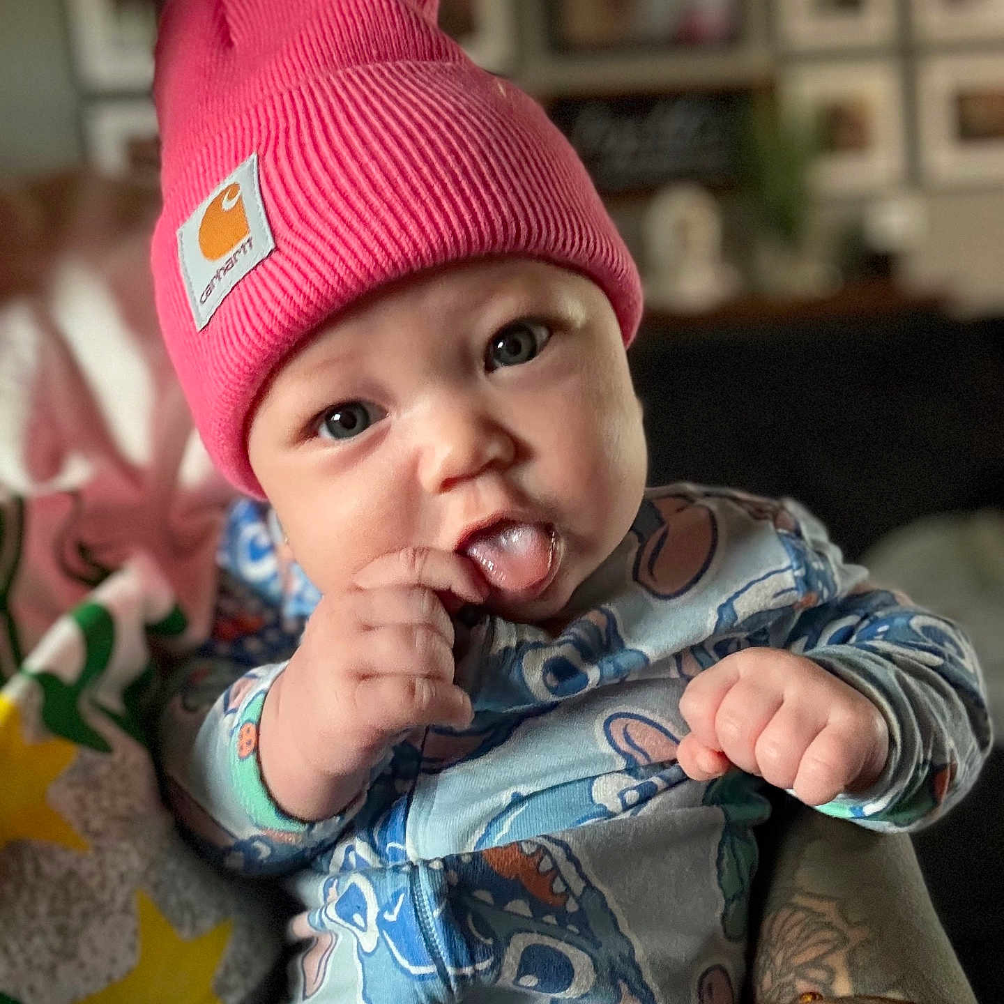 Saraiyah joined the competition — help win amazing prizes! baby, beanie, blue_eyes, blurred_background, child, cute, face, hand, hat, holding, home, indoor, infant, onesie, patterned_clothing, person, pink, playful, tattoo, tongue_out