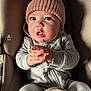 baby, car_seat, child, closeup, cozy, cute, expression, eyes, face, gray_clothing, hands, indoor, infant, knit_hat, pom_pom, portrait, seat_belt, sitting, small_person, warm_clothing