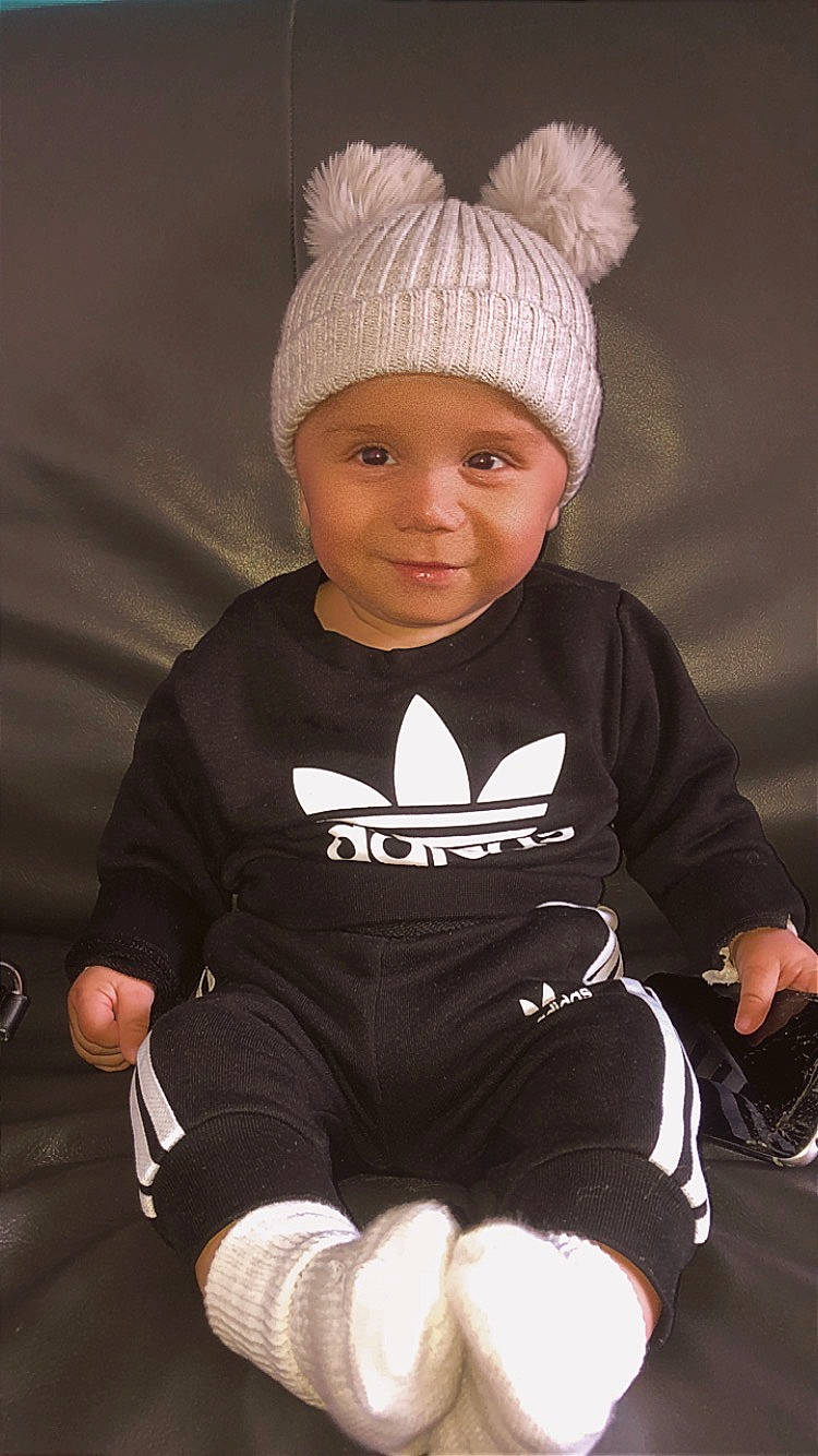 Liyam participe au concours pour gagner de l'argent avec cette photo : baby, baby_toddler_clothing, cap, cheek, child, comfort, eye, face, fashion_accessory, happy, head, headgear, headwear, knit_cap, person, personal_protective_equipment, sitting, skin, sleeve, smile