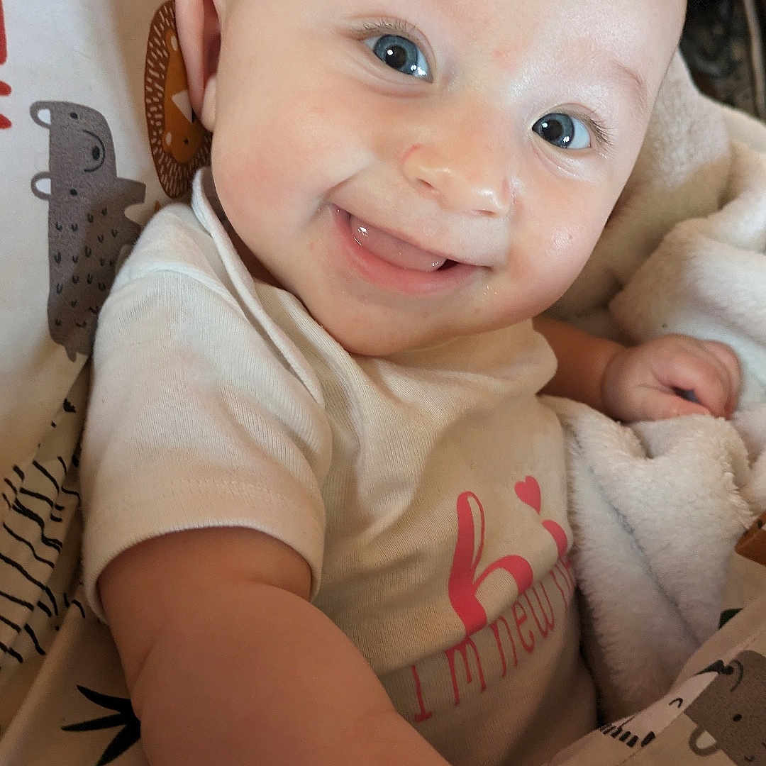 Lola joined the competition — help win amazing prizes! baby, babylaughing, blanket, bodypart, clothing, couch, cushion, face, finger, hand, happy, head, homedecor, laughing, newborn, person, photography, portrait, smile, t_shirt