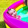 toddler, child, pool, inflatable_pool, rainbow, grass, summer, happy, smiling, water, outdoor, play, fun, cute, baby, pink, yellow, green, blue, sunlight
