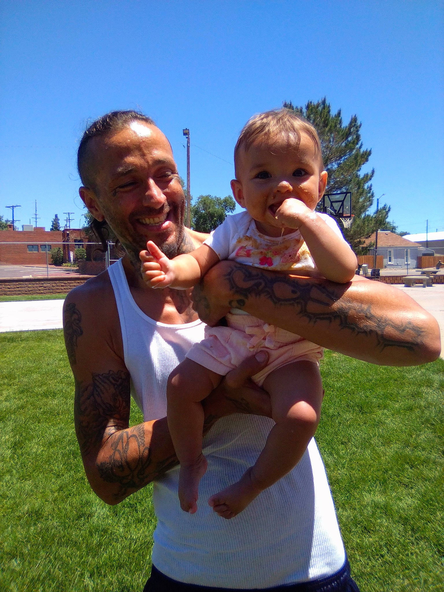 Wynter is registered to the contest to win money with this photo: arm, baby, facial_expression, finger, fun, gesture, grass, hairstyle, happy, interaction, joy, leisure, people_in_nature, person, plant, shorts, sky, smile, sunlight, t_shirt