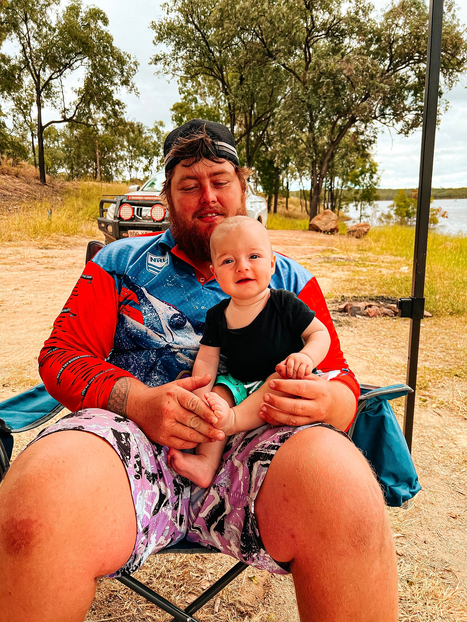 Jayden joined the competition — help win amazing prizes! event, fun, grass, happy, human_leg, landscape, lap, leg, leisure, people_in_nature, person, plant, recreation, shorts, sitting, sky, summer, t_shirt, thigh, toddler