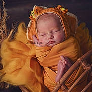 Iris participe au concours pour gagner de l'argent avec cette photo : newborn, baby, sleeping, orange, blanket, bonnet, flower, wicker_basket, yellow_fabric, cozy, autumn, portrait, infant, cute, resting, soft, peaceful, wrapped, child, indoors