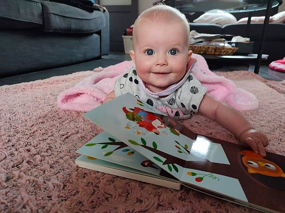 Maëlle participe au concours pour gagner de l'argent avec cette photo : baby, baby_toddler_clothing, carpet, cheek, child, comfort, floor, flooring, happy, hardwood, joy, linens, pattern, person, room, sitting, sleeve, smile, t_shirt, textile