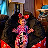 child, toddler, smiling, pajamas, minnie_mouse_ears, bean_bag_chair, puppy, dog, indoor, lamp, door, high_chair, happy, feet, hand, person, furniture, curtain, home, cute