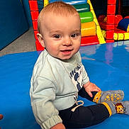 Ayrton participe au concours pour gagner de l'argent avec cette photo : baby, child, smiling, sitting, indoor, playground, colorful, clothing, sock, face, person, toy, play_area, happy, cute, young_child, sweatshirt, floor_mat, bright, portrait
