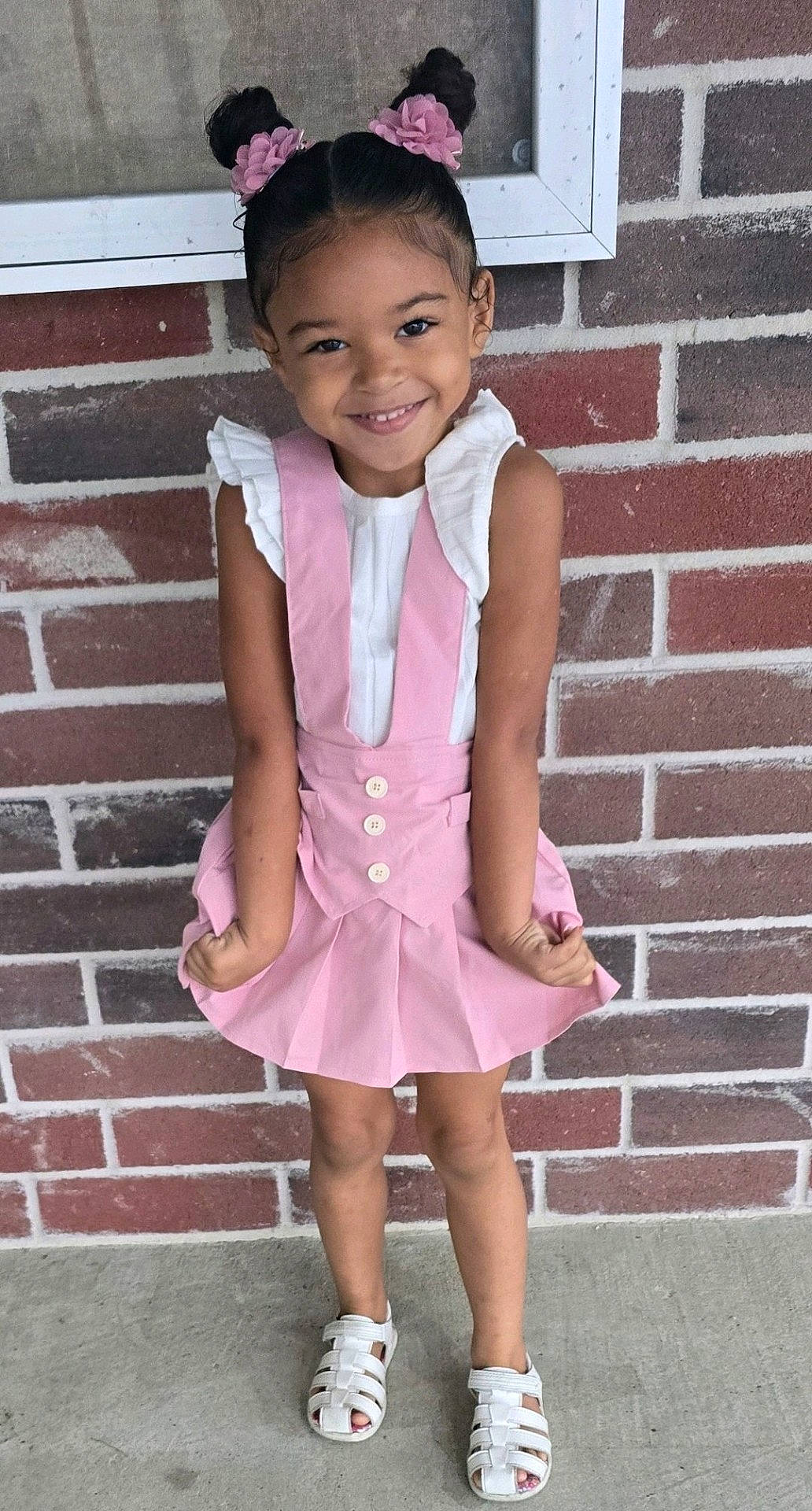 architecture, brick, building, child, clothing, dress, face, female, footwear, girl, head, person, photography, portrait, sandal, shoe, shorts, skirt, sneaker, wall