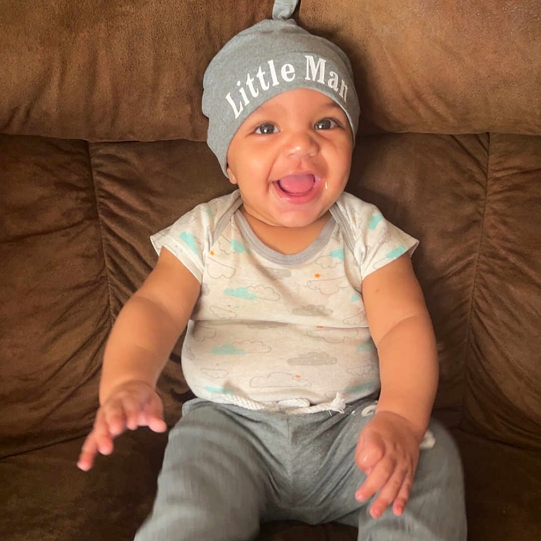 Elijah is registered to the contest to win money with this photo: baby, child, clothing, couch, cute, expression, face, furniture, happy, hat, indoors, infant, joyful, pants, person, portrait, sitting, skin, smile, socks