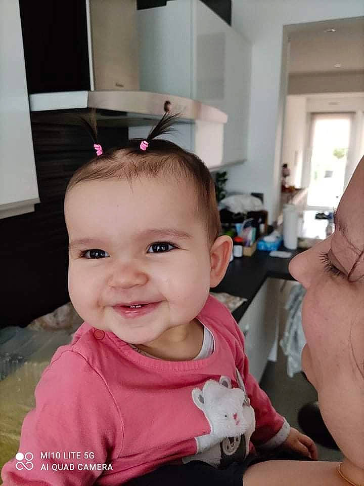 Nélia participe au concours pour gagner de l'argent avec cette photo : arm, baby, baby_toddler_clothing, chair, cheek, child, ear, eyebrow, eyelash, face, finger, fun, gesture, happy, joy, kitchen_appliance, person, room, skin, sleeve