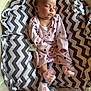 baby, sleeping, infant, onesie, pink_clothing, polka_dot, socks, frills, blanket, chevron_pattern, bassinet, mesh_sides, pacifier, soft_lighting, indoor, cute, peaceful, resting, child, portrait