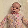 Cassi joined the competition — help win amazing prizes! baby, infant, onesie, floral_pattern, blanket, lying_down, cute, child, face, expression, pink, purple, yellow, white, soft, texture, sleepwear, young, portrait, indoors