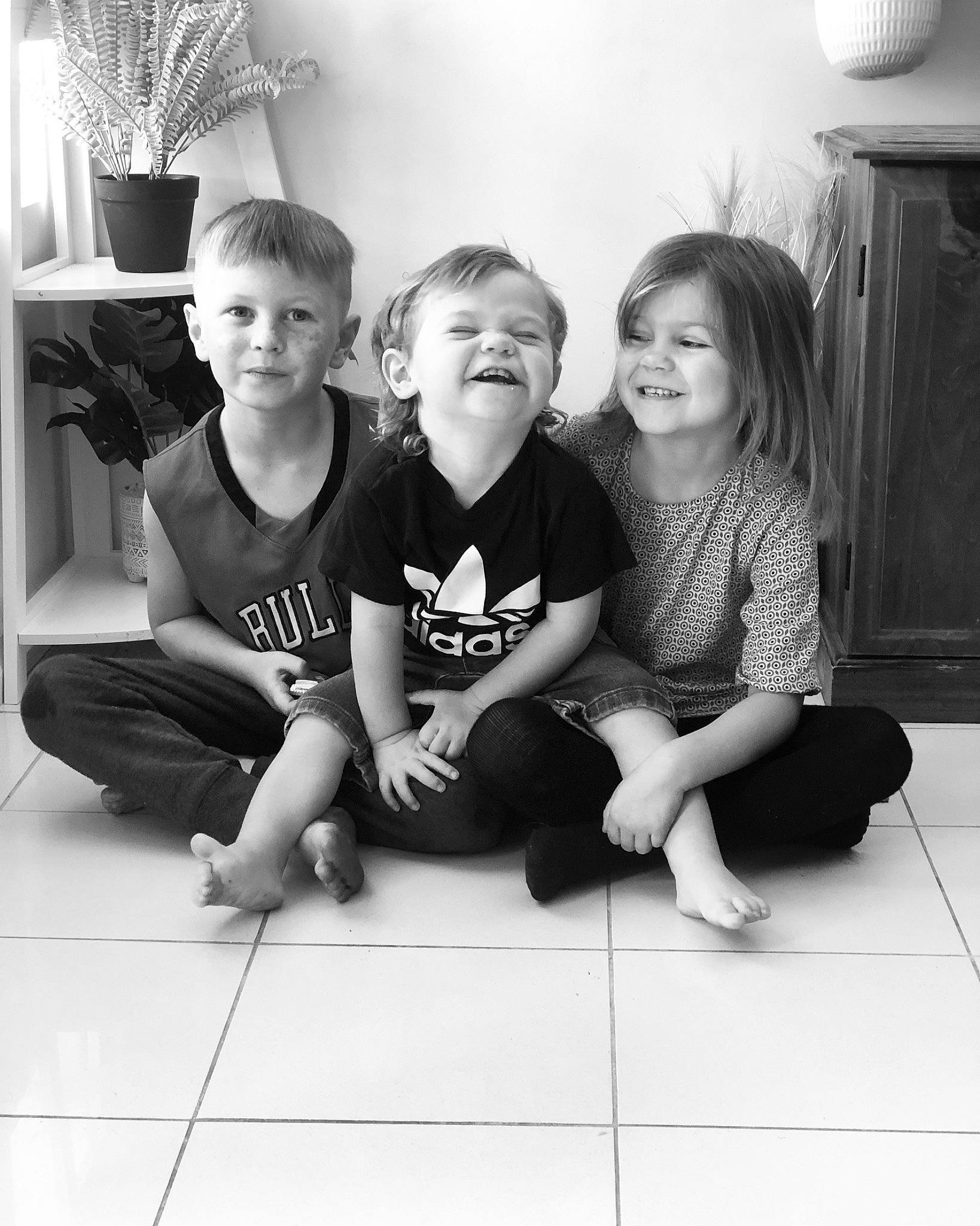 Kohen is registered to the contest to win money with this photo: black, black_and_white, child, facial_expression, flash_photography, floor, flooring, fun, gesture, happy, human, joy, mammal, person, photograph, shorts, smile, standing, style, t_shirt