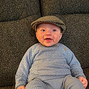 Roman joined the competition — help win amazing prizes! baby, child, smiling, cap, hat, blue_clothing, sitting, couch, indoor, knitwear, happy, portrait, cute, infant, human, one_person, face, headwear, casual, relaxed