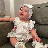 Ivy-Rae is registered to the contest to win money with this photo: architecture, baby, bonnet, building, cap, clothing, couch, cushion, dress, face, footwear, furniture, hat, head, homedecor, person, photography, portrait, shoe, sitting