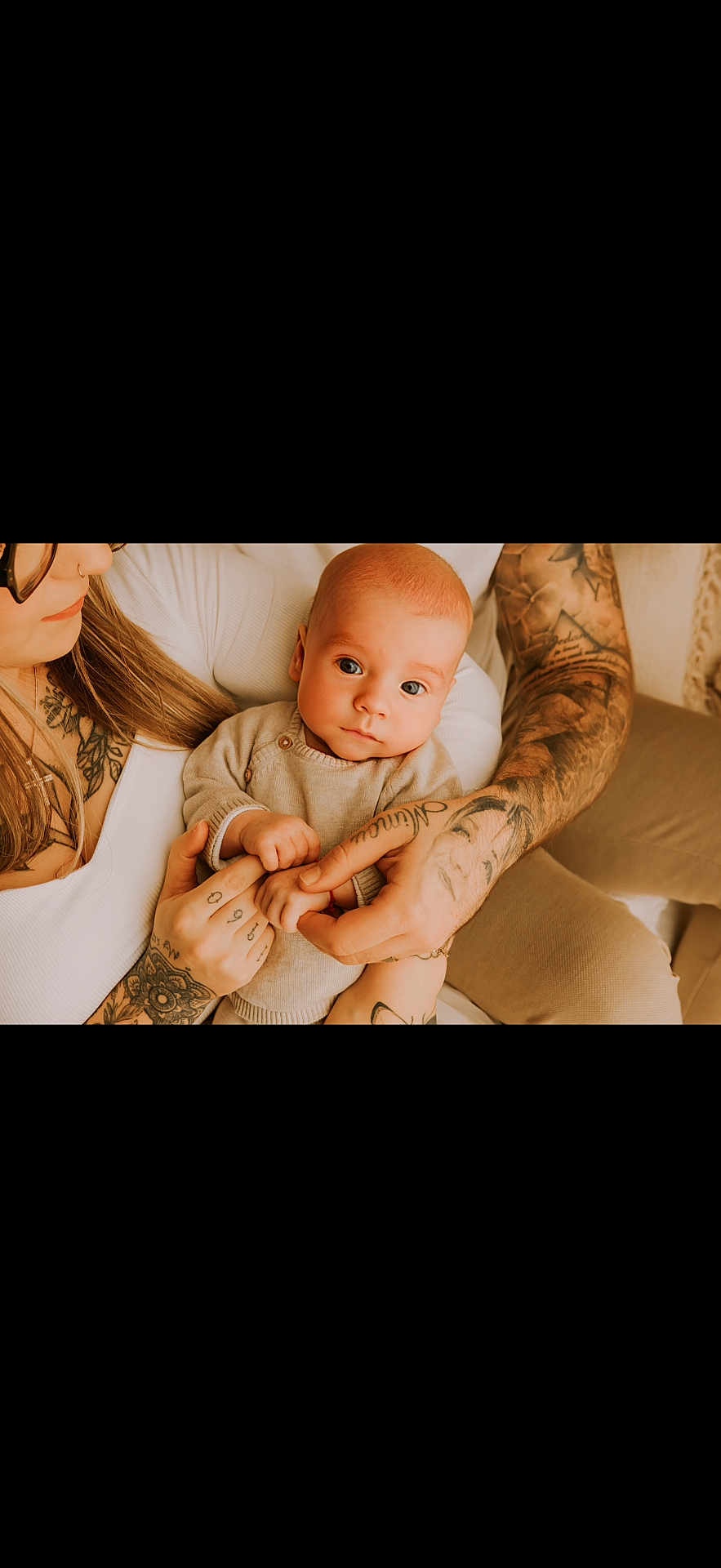 Sladjan a rejoint le concours — aidez-le/la à gagner de superbes lots ! baby, tattoos, hands, adult, woman, infant, portrait, closeup, warm_lighting, skin, couch, clothing, indoor, family, love, holding, person, casual, relaxed, gentle