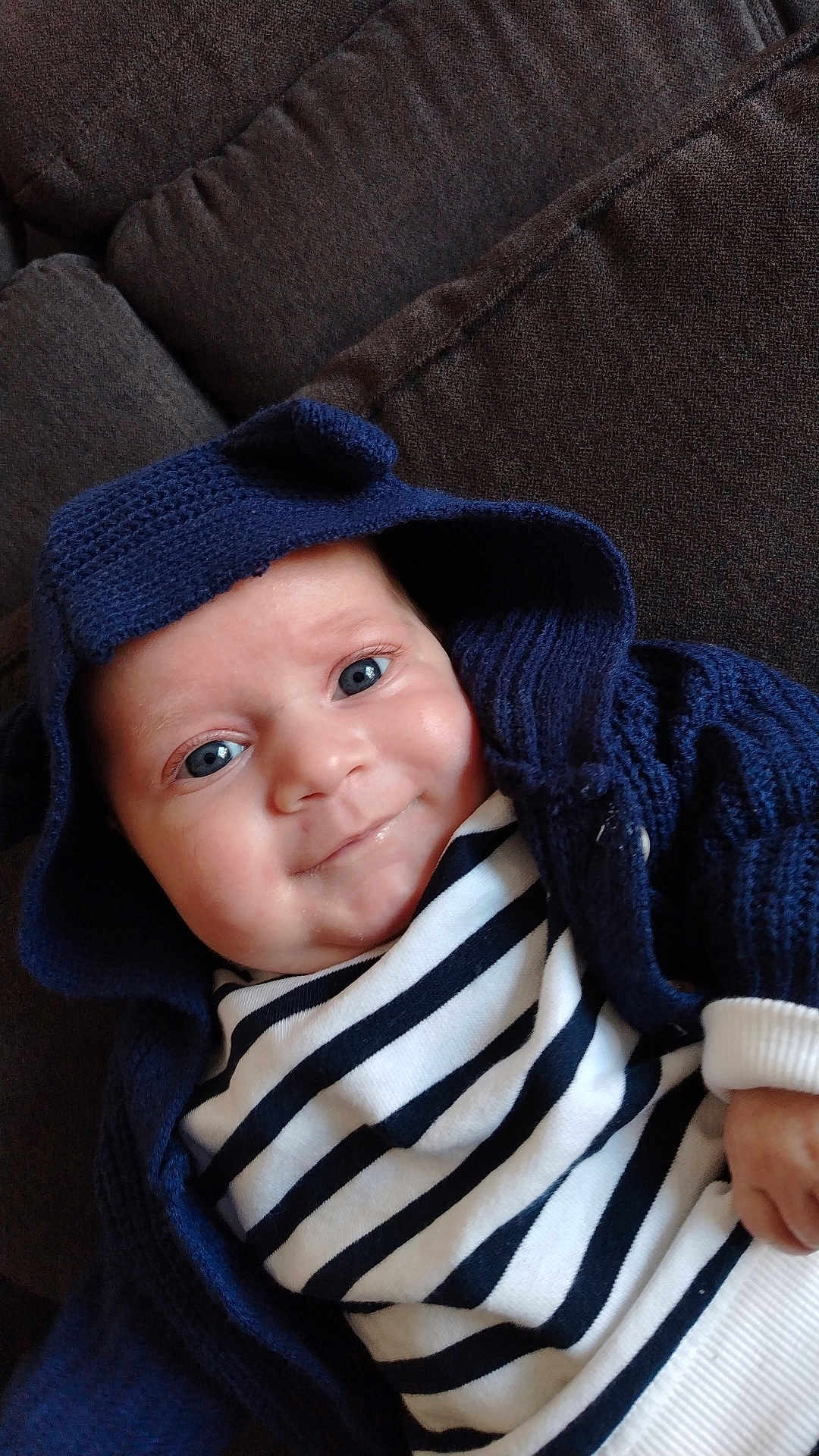 ézio a rejoint le concours — aidez-le/la à gagner de superbes lots ! baby, infant, smile, hoodie, knitted_clothing, blue_eyes, striped_shirt, couch, fabric, cozy, cute, portrait, child, young, indoor, apparel, person, closeup, happy, face