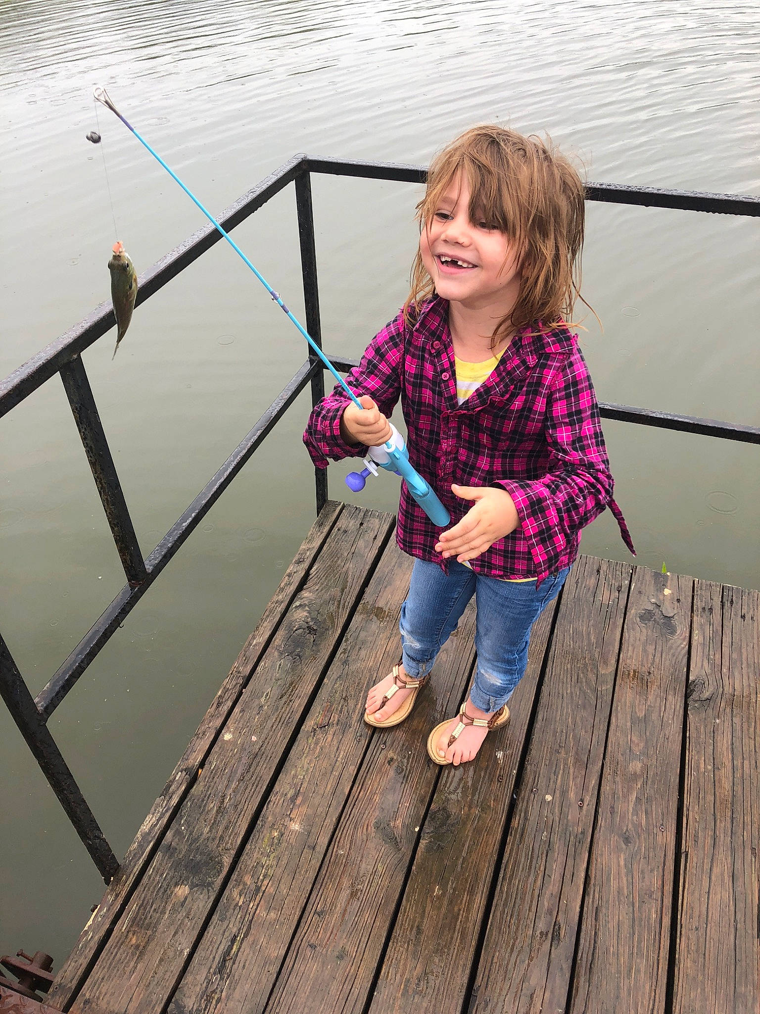 Trinity is registered to the contest to win money with this photo: boats_and_boating_equipment_and_supplies, bridge, child, dock, fishing_rod, joy, leg, leisure, nonbuilding_structure, person, pier, pink, recreation, smile, vacation, water