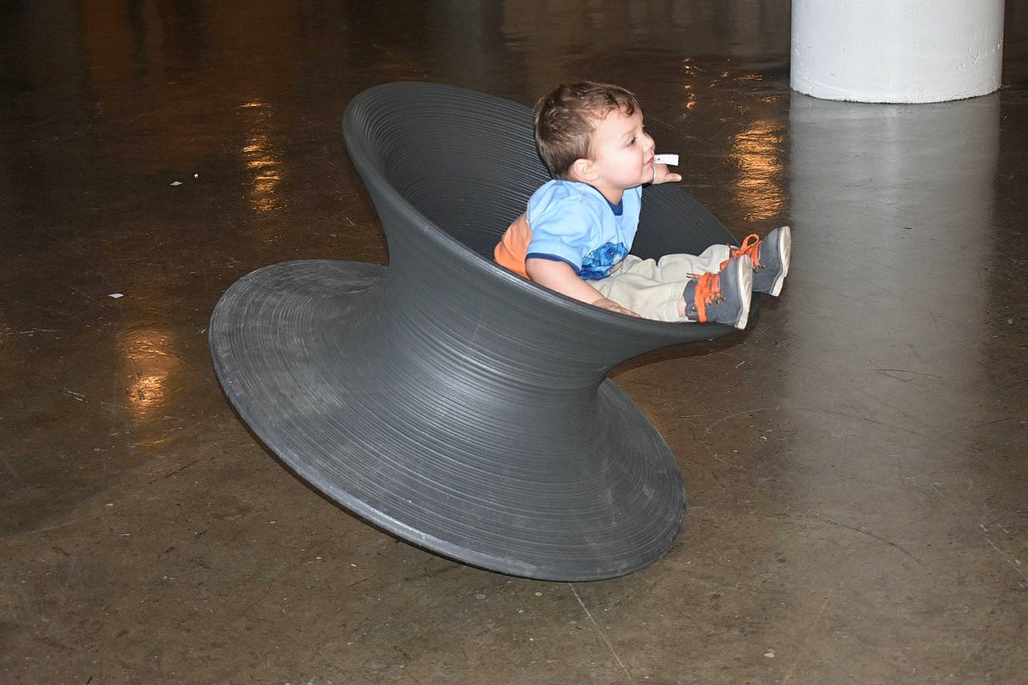 Leonardo is registered to the contest to win money with this photo: chair, child, concrete, floor, flooring, person, sitting, space, toddler