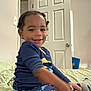 Nolan is registered to the contest to win money with this photo: child, toddler, smile, pajamas, bed, indoor, door, room, wall, light_switch, socks, hair, face, person, furniture, blanket, blue, yellow, toy, casual