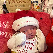 Savannah joined the competition — help win amazing prizes! baby, infant, christmas, holiday, santa_hat, blanket, red, festive, clothing, cute, sleepy, newborn, decorations, wooden_sign, text, celebration, christmas_outfit, holiday_season, person, portrait