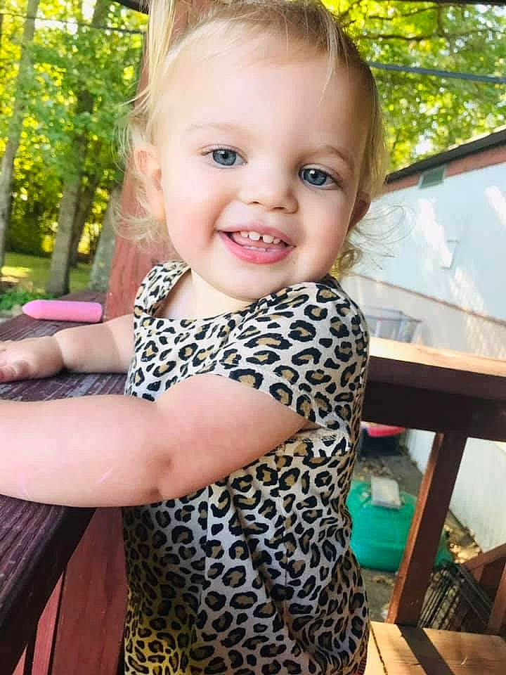 Alaina is registered to the contest to win money with this photo: arm, baby_toddler_clothing, eye, face, gesture, hair, hairstyle, hand, happy, human_body, iris, joint, joy, neck, person, plant, shoulder, skin, sleeve, smile