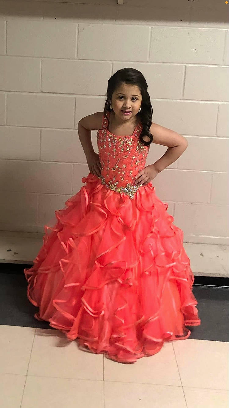 Amelia is registered to the contest to win money with this photo: bridal_accessory, bridal_clothing, bridal_party_dress, clothing, day_dress, dress, embellishment, face, fashion_design, flooring, formal_wear, gown, happy, joy, neck, one_piece_garment, outerwear, person, pink, ruffle