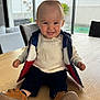 Hugo participe au concours pour gagner de l'argent avec cette photo : baby, smiling, indoor, table, clothing, vest, sweater, shoes, window, furniture, child, portrait, happy, person, light, wood, casual, cute, home, seated